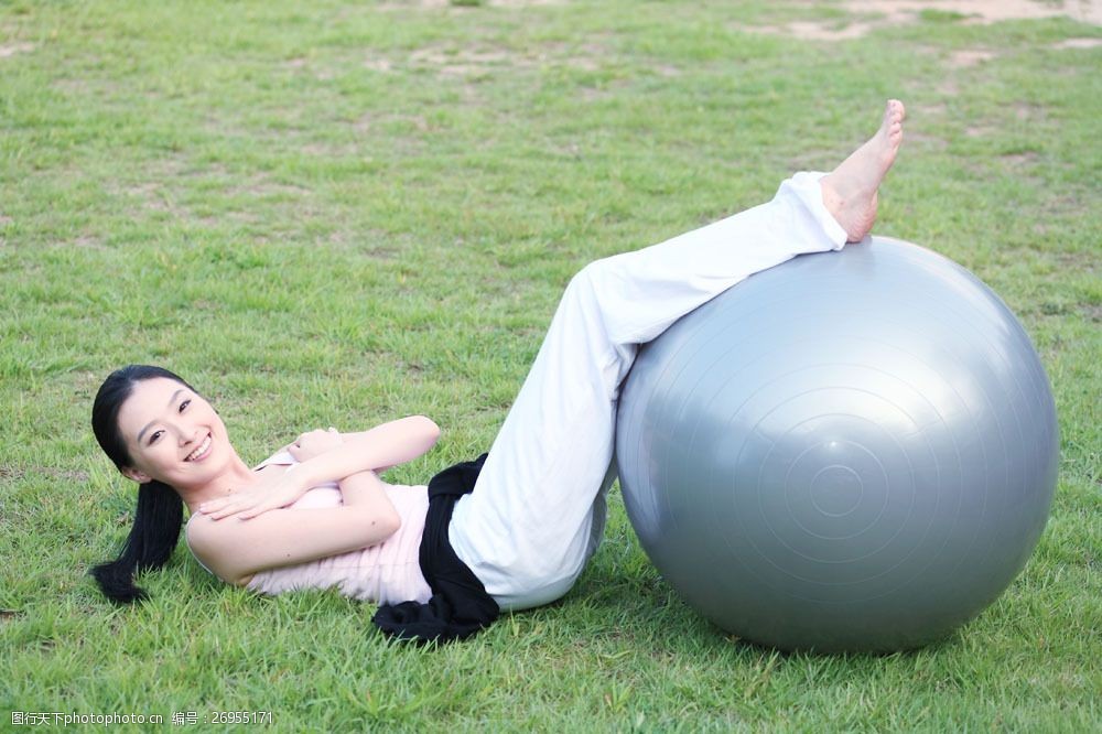躺在草地上做运动的瑜伽少女图片图片
